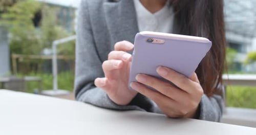 Frau benutzt Handy im Café im Freien