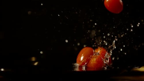 Kirschtomaten fallen ins Wasser, Ultra-Slow-Motion
