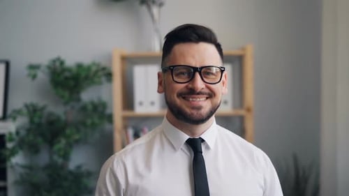 Slow Motion Portrait of Businessman Looking at Camera and Smiling in Office