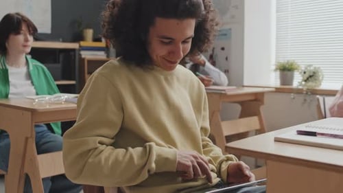 Un mec biracial utilisant une tablette en classe