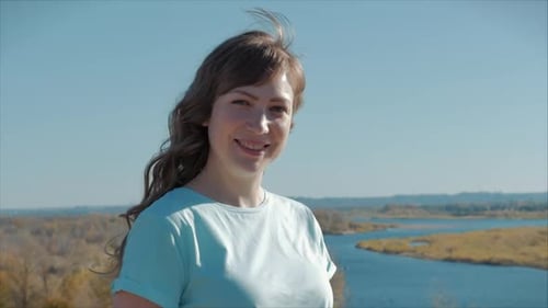 Smiling Woman Outdoors by Winding River