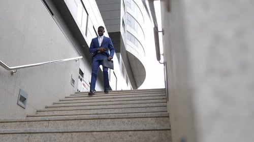 Businessman Walking Down Stairs in Urban Setting