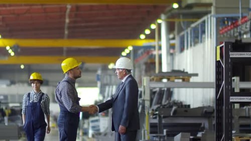 Engineers Shake Hands in a Factory
