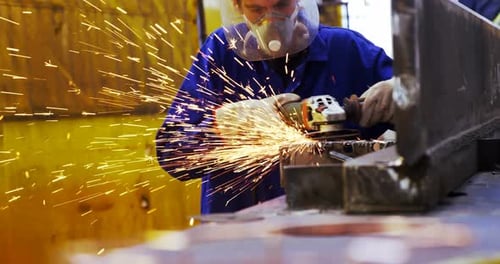 Male engineer using grinder machine