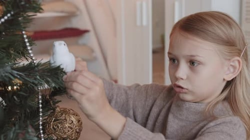 Girl Placing Toy Bird on Spruce Branch