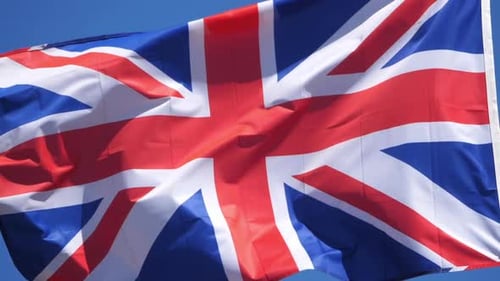 United Kingdom Flag Waving Against Blue Sky