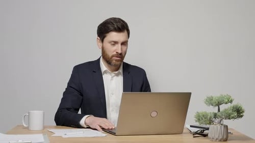 Man in Suit Using Laptop for Video Conference