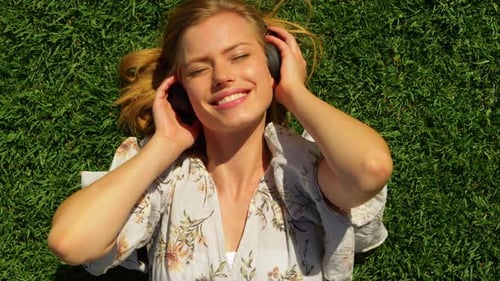 Woman Relaxing on Grass with Headphones