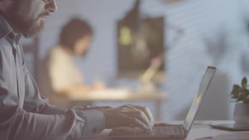 Man Working on Laptop in Dark Office