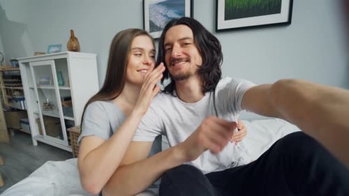 POV von Mann und Frau, die zu Hause im Bett Selfie mit Kameraküssen machen