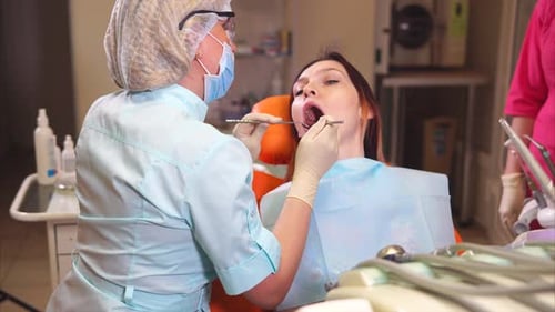 Dentist Examining Patient's Teeth in Medical Office