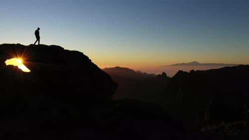 Man Watching Sunset From Mountain Rock Arch