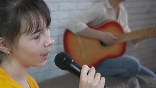 Girl Singing With Guitar Accompaniment at Home