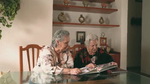 Senior Women Looking Through Photo Album at Home