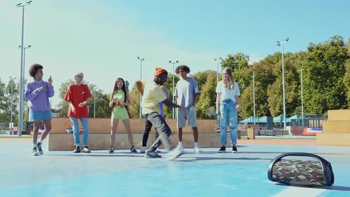 Young Adults Dancing Together in Urban Park on Sunny Day