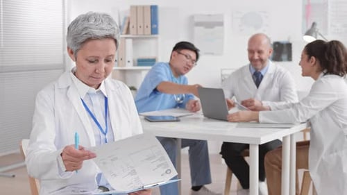 Médecin senior feuilletant des documents