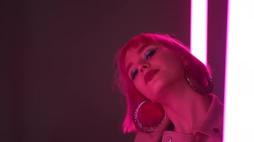 Woman with Pink Hair Posing by Neon Lights