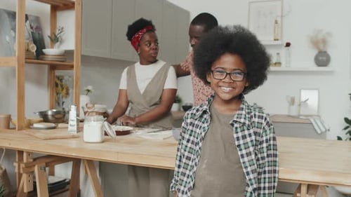 Boy Smiles as Parents Bake in Kitchen
