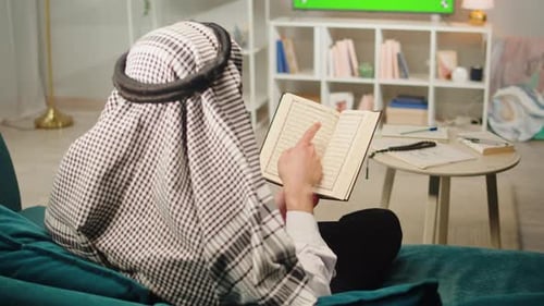Person Reading Book in Living Room Setting