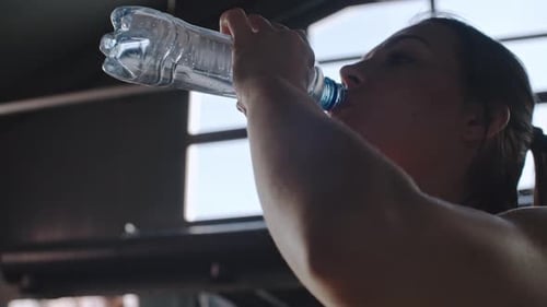 Athletic Woman Drinks Water After Workout