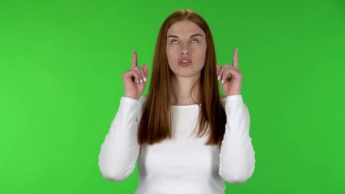 Enthusiastic Young Woman Pointing and Gesturing on Green Screen