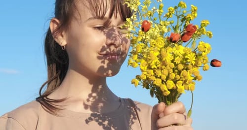 Girl Holding Bouquet of Yellow Wildflowers Smiling