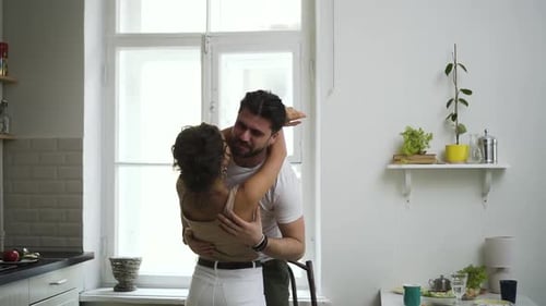 Affectionate Couple Embracing in Bright Kitchen
