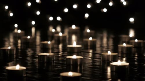 Many Candles Flicker in Dark Setting