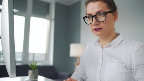Woman Typing at Computer in Modern Workspace