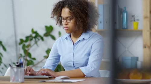 Junge schwarze Frau arbeitet am Computer