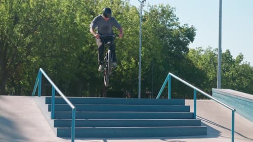 Man Jumps Bike at Skate Park