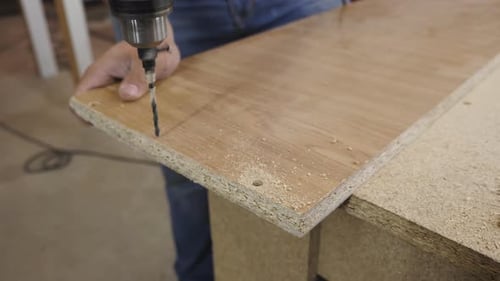 Man Drilling Wood Plank with Power Drill