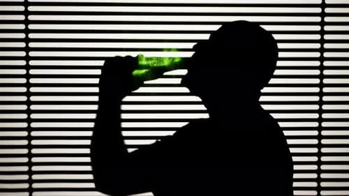 Hombre bebiendo cerveza sobre fondo rayado blanco