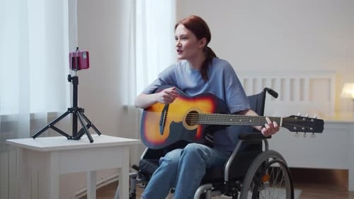 Woman in Wheelchair Plays Guitar and Sings