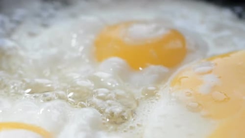 Eggs Sizzling in a Frying Pan Close Up