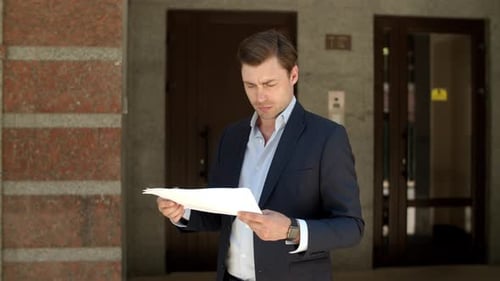 Closeup Man Reading Documents. Businessman Looking at Documents at Street