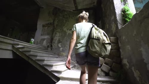 Junge schöne Touristin geht durch verlassenes Gebäude