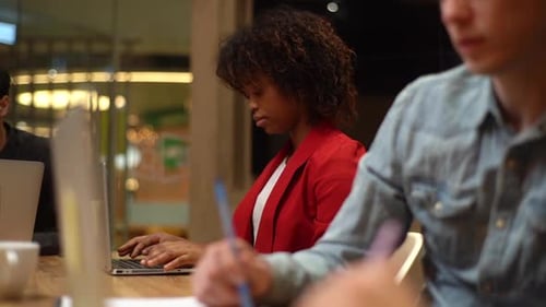 Closeup of Two Young Business Partners Working in Modern Office Looking at Laptop Computer Screen