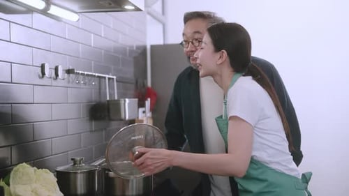 Adult Woman and Senior Man Cooking in Kitchen