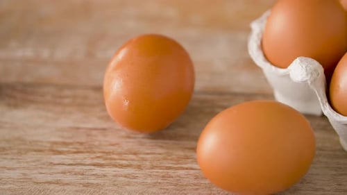 Close Up of Eggs in Cardboard Box on Wooden Table