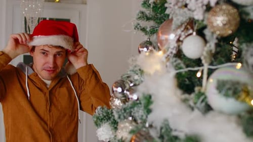Smiling Man Putting on a Santa Hat Indoors