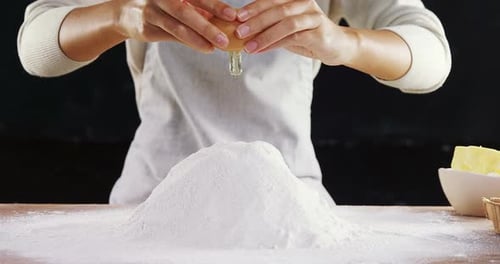Cracking Egg Over Flour For Baking Preparation