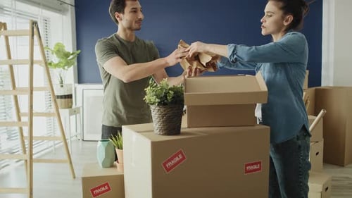 Young Couple Unpacking Boxes in New Home