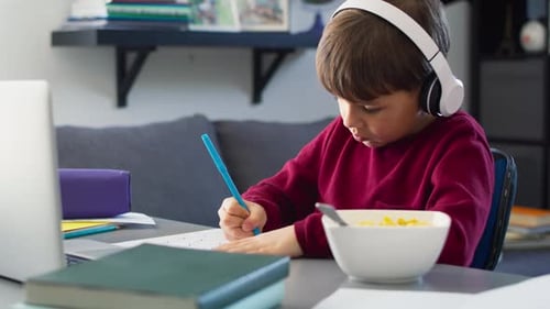 Young Boy Studying and Writing at Desk
