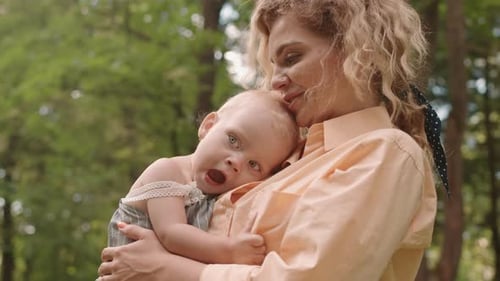 Mother with Toddler Daughter on Hands Outdoors