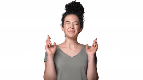 Woman Smiling with Fingers Crossed Hoping for Luck