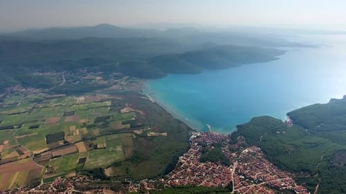 Eine kleine Stadt an einer bewaldeten Bucht und einer fruchtbaren Auenebene am Meer