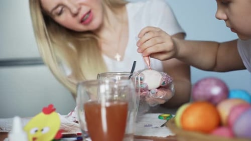 Mother and Child Decorating Easter Eggs at Home