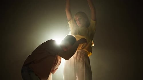 Duet Dancing Together in Dark Studio with Light