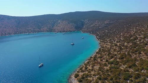 Catamaran and Sail Yachts Anchored at Bay on Deep Blue Sea Water on Sunrise